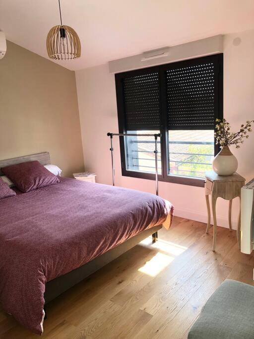 a bedroom with a purple bed and a window at Standing, calm &amp; confort. in Bègles