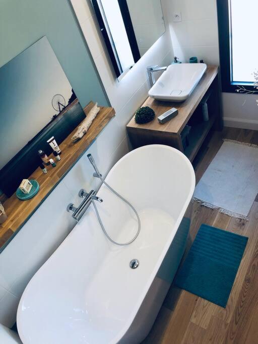 a bathroom with a white tub and a sink at Standing, calm &amp; confort. in Bègles