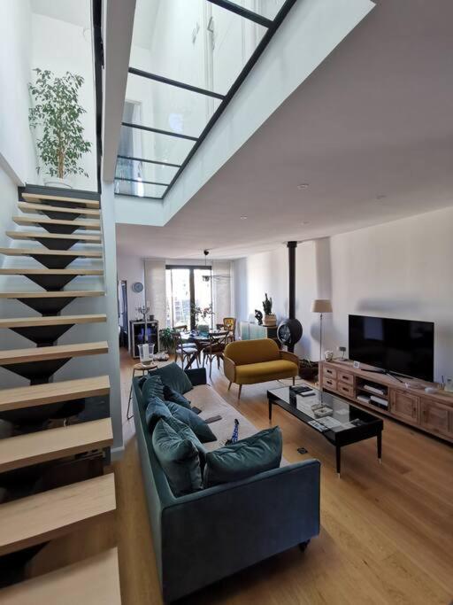 a living room with a staircase and a couch at Standing, calm &amp; confort. in Bègles