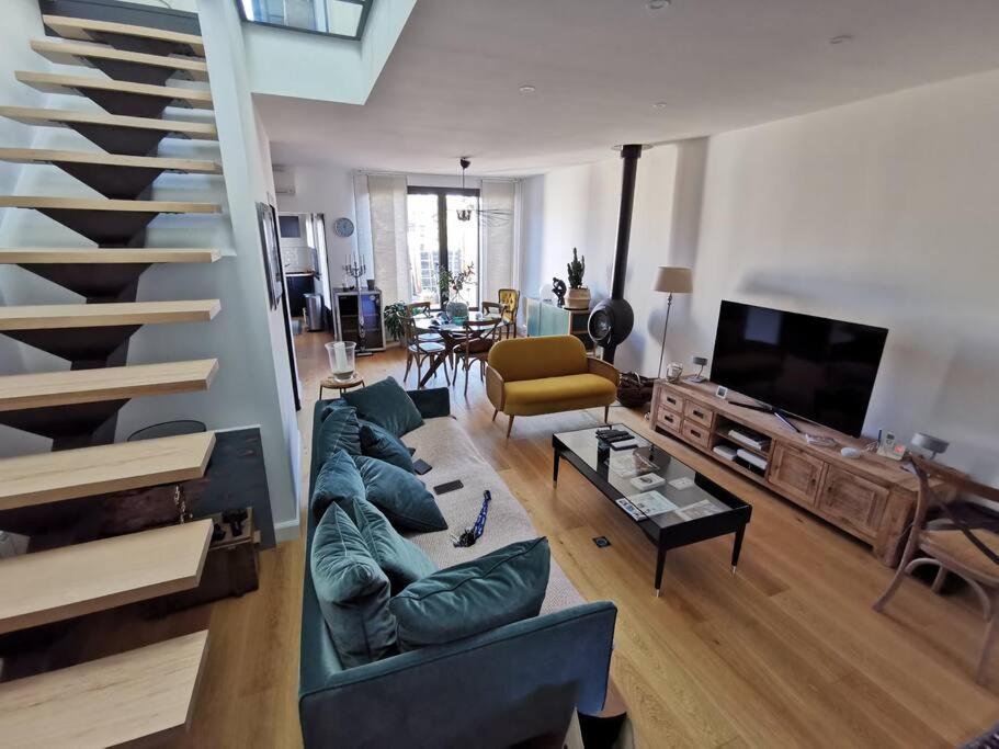 a living room with a couch and a staircase at Standing, calm &amp; confort. in Bègles