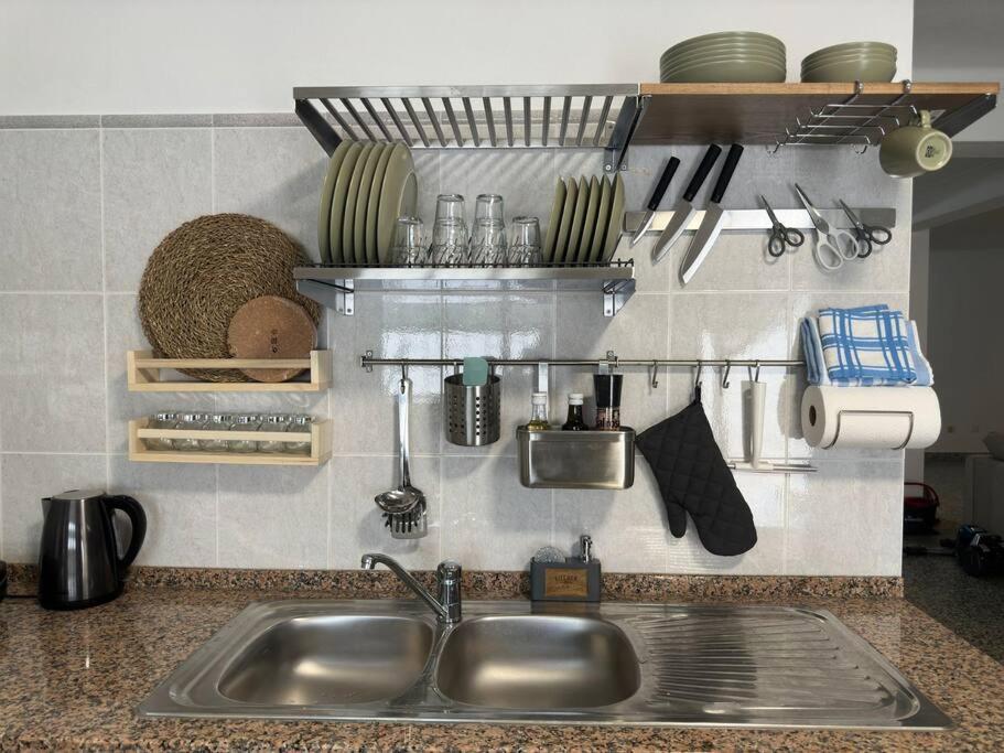 eine Küchentheke mit Spüle und einigen Utensilien in der Unterkunft Apartamento Estudio Com Entrada Privada in Arrentela