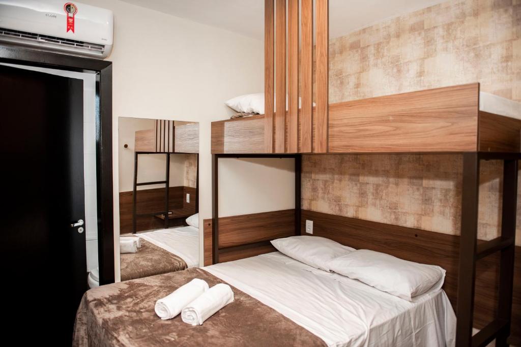 a bedroom with two bunk beds with white towels at Uny Hotéis Brás in Sao Paulo