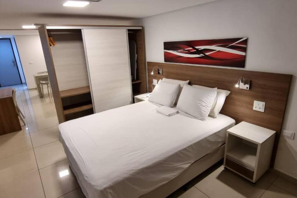 - une chambre avec un grand lit blanc et des oreillers blancs dans l'établissement Imperial Flat Tambaú, à João Pessoa