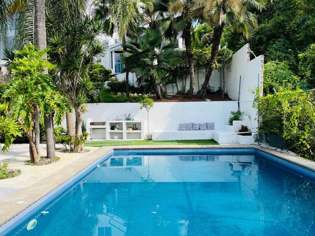 una piscina frente a una casa con palmeras en Casa en Residencial San Gaspar, en Jiutepec