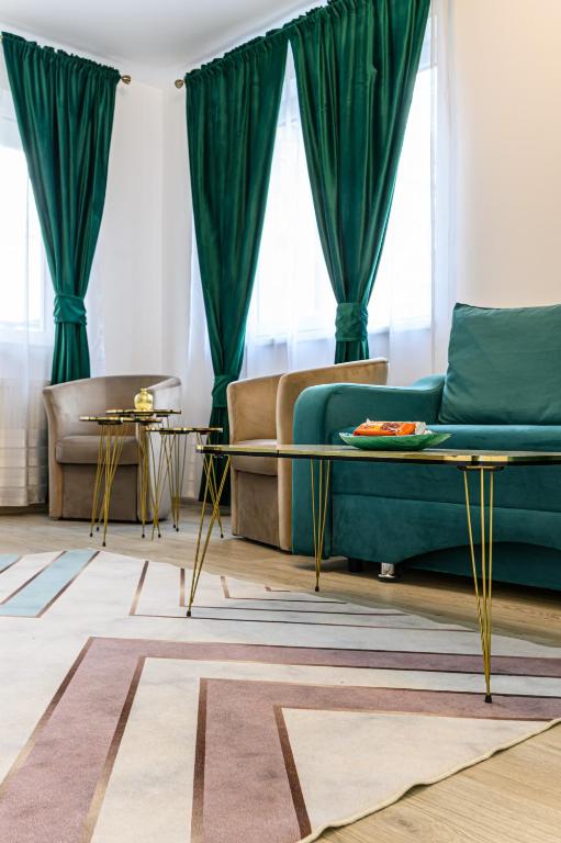 a living room with a green couch and two tables at Grandis Coresi Mall Luxury Apartment in Braşov