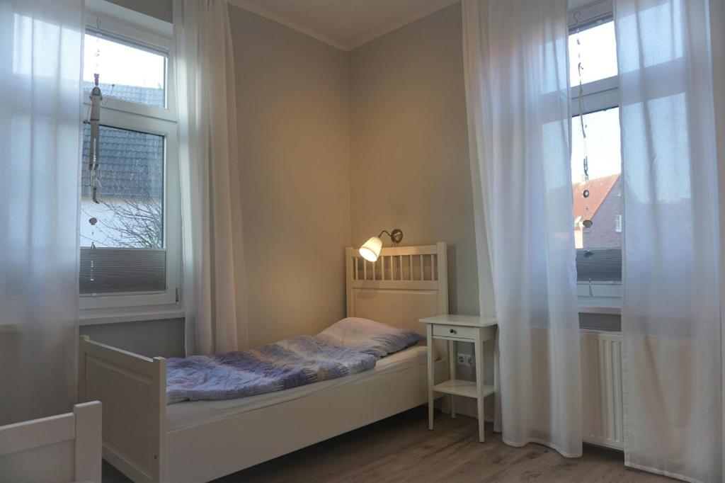 ボルクムにあるDe Vischer un sin Fruの小さなベッドルーム(ベッド1台、窓2つ付)が備わります。