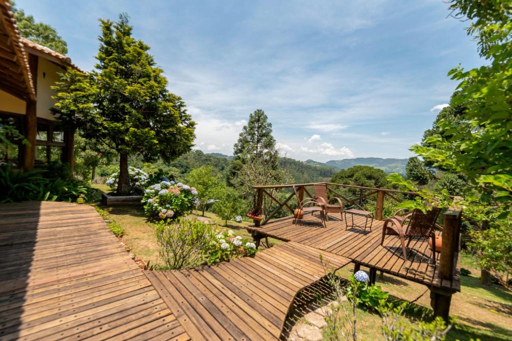 una terraza de madera con vistas a las montañas en Pousada Serra Vista en Gonçalves