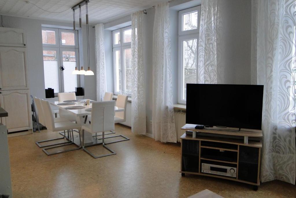 a living room with a tv and a table with chairs at Seestern in Kappeln