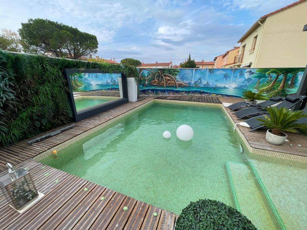 a swimming pool with two balls in the water at Relaxation AquatiqueGarantie100% in Saint-Estève
