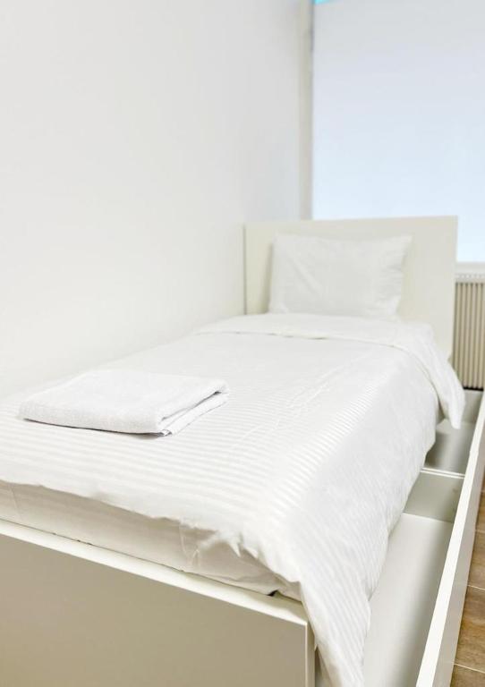 uma cama branca com lençóis e almofadas brancos em Wohnung alleinige Nutzung 40m² 4 Schlafplätze Wiesbaden em Wiesbaden