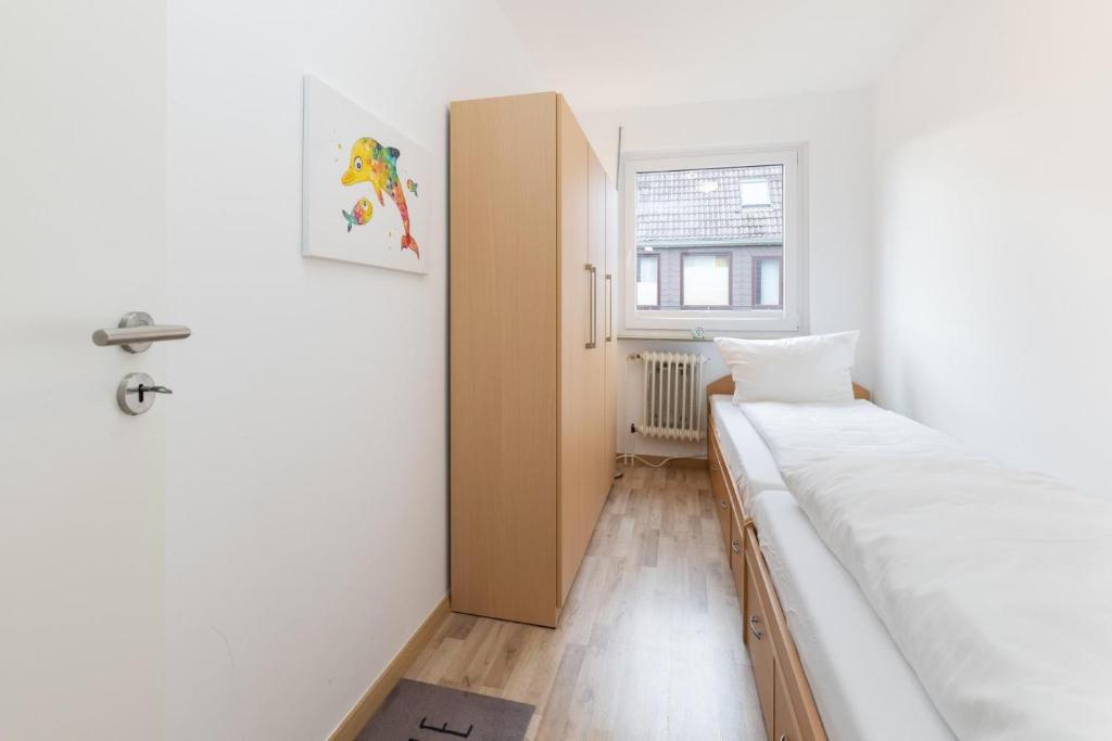 um pequeno quarto com uma cama e uma janela em Möwe4 em Büsum