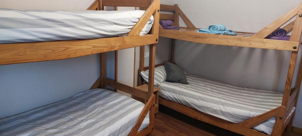 a couple of bunk beds in a room at Peña del viento a pie de pistas estación San Isidro in Puebla de Lillo