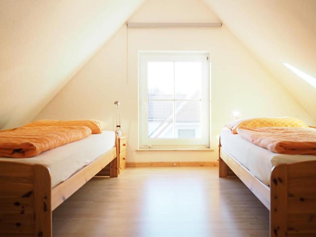 2 Betten in einem Zimmer mit Fenster in der Unterkunft Apartments Haus an der Stems 30 & 31 in Prerow