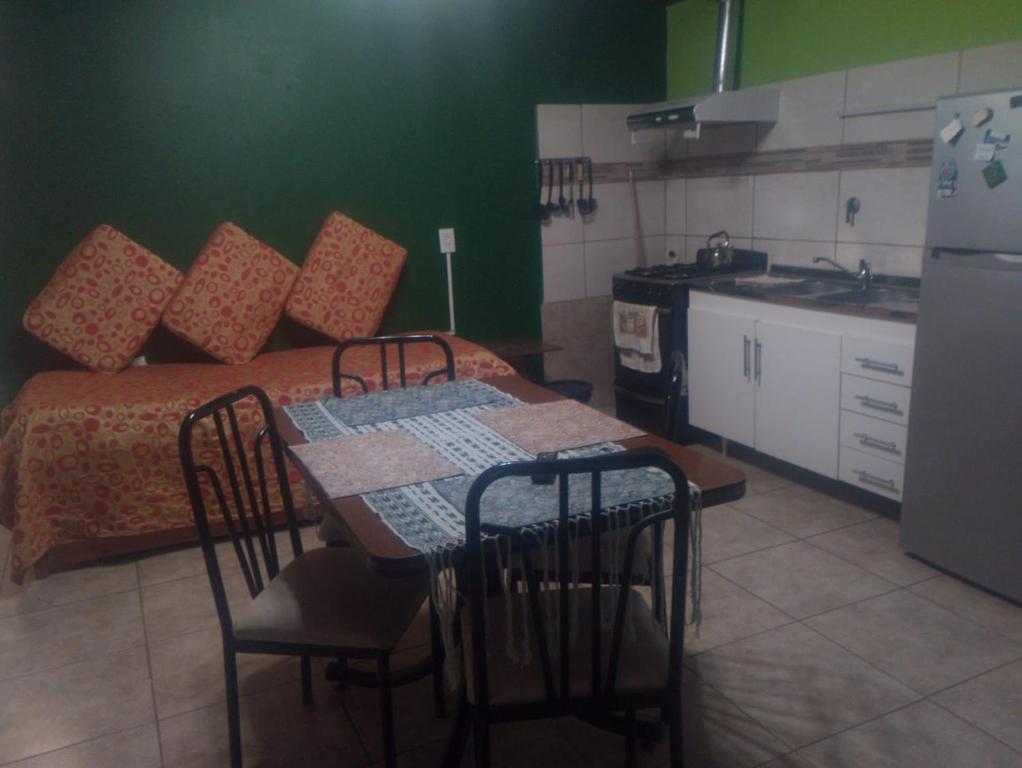 a kitchen with a table with chairs and a bed at Hospedaje Michay in Ushuaia