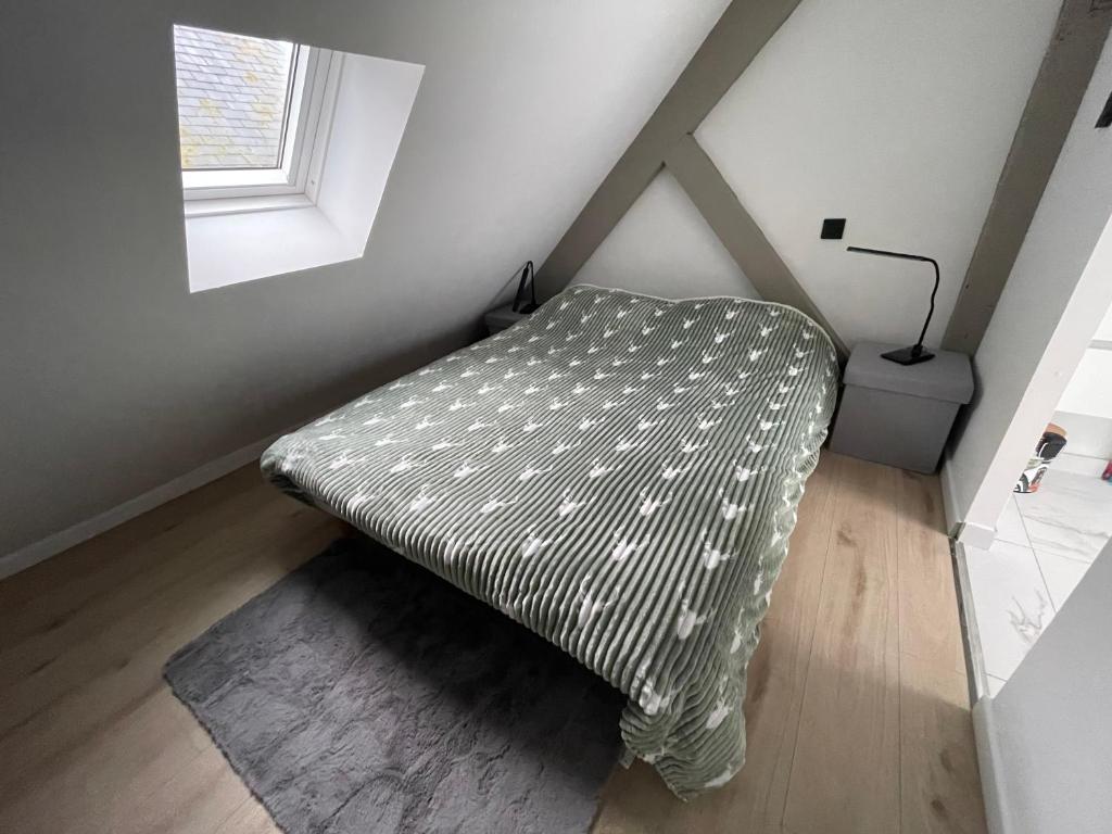 1 cama en la esquina de una habitación con ventana en Le Mouscoul de Saint Guénolé, en Penmarch