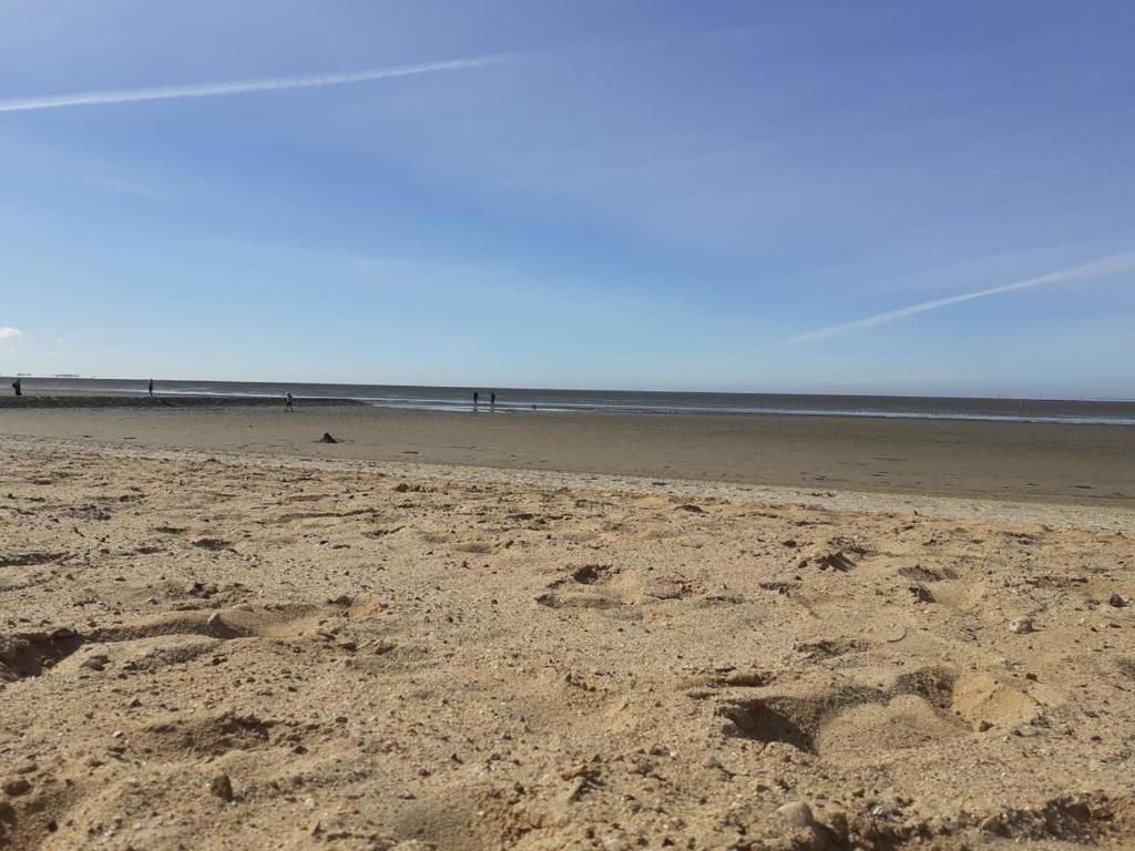 a sandy beach with footprints in the sand at Ferienwohnung Seestern in Cuxhaven