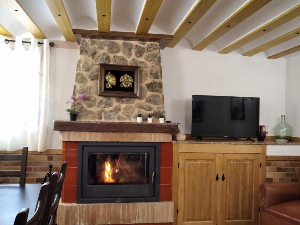 sala de estar con chimenea y TV en VENTA DE LA CASA NOGUERA en Riópar