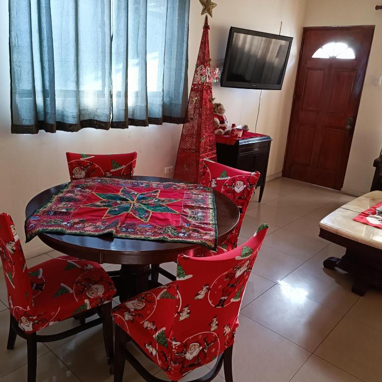 a dining room with a table and red chairs at Casa dos dormitorios in Iquique