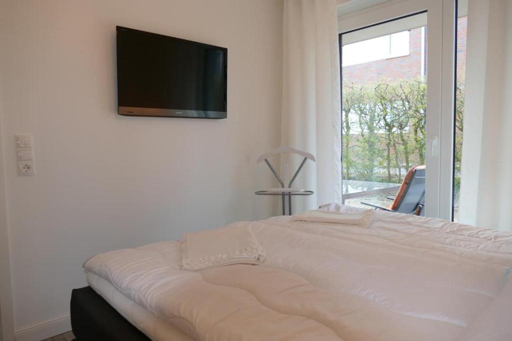 a bedroom with a bed with a television on the wall at Meeresbrise in Scharbeutz