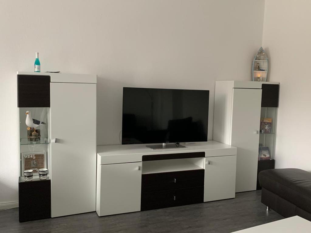 uma sala de estar com televisão num centro de entretenimento branco em Bellevue Nr. 35 em Scharbeutz