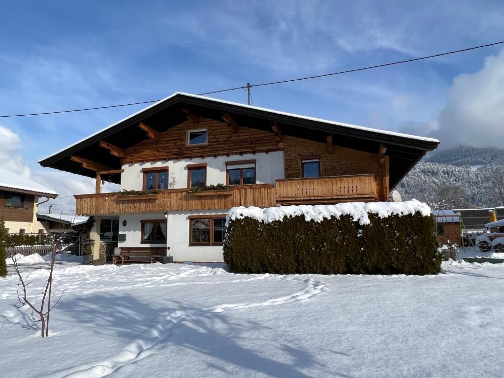een huis met sneeuw op de grond ervoor bij Apartment Lopez in Sankt Johann in Tirol