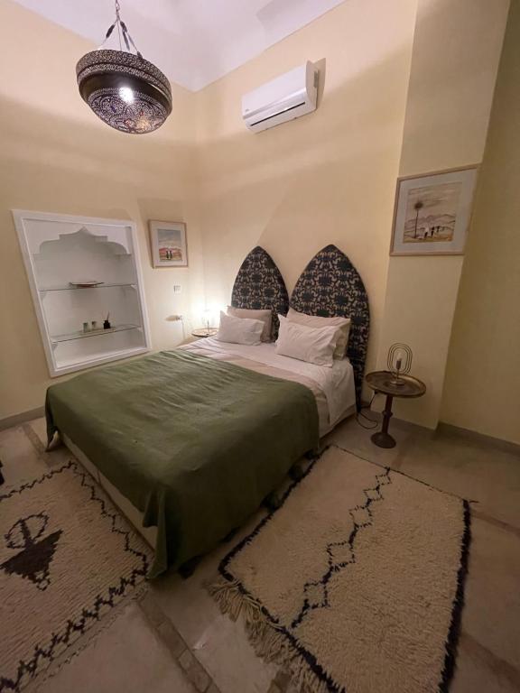 - une chambre avec un lit doté d'un couvre-lit vert dans l'établissement RIAD DAR NAOMI, à Marrakech