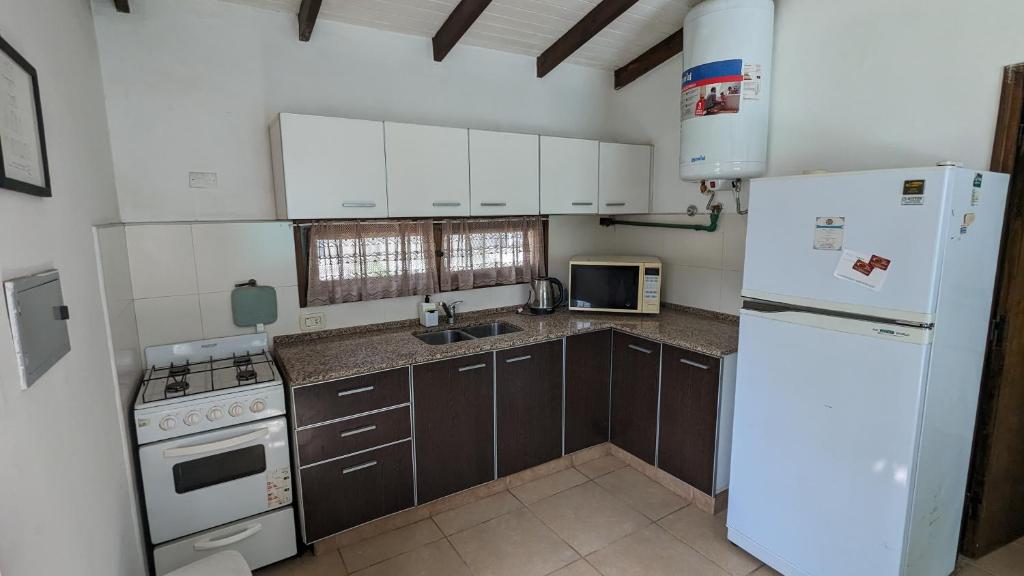 una cocina con electrodomésticos blancos y armarios marrones en Besares en Luján de Cuyo