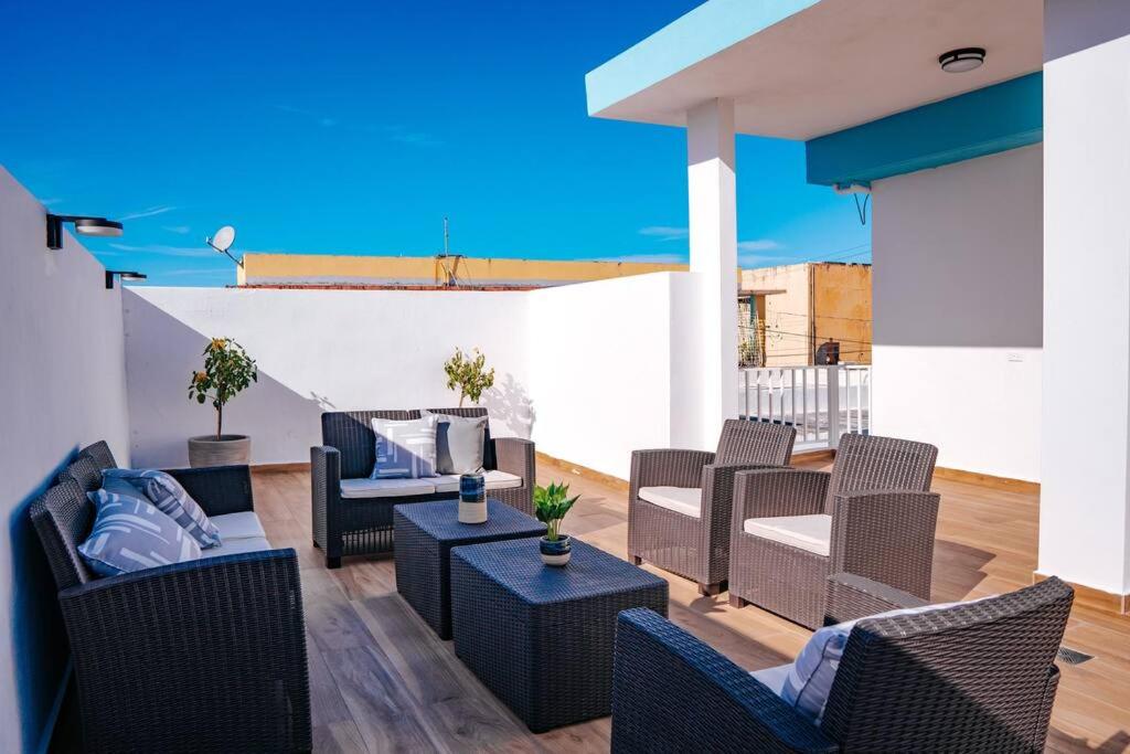 d'une terrasse avec des canapés, des tables et une télévision. dans l'établissement Casita Style Apt 3 w/ Sofa Bed & Patio @ Santurce, à San Juan