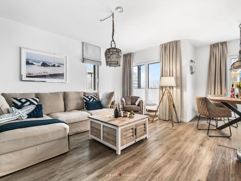 una sala de estar con un sofá y una mesa en Ferienwohnung AusZeit 24 7, en Damp