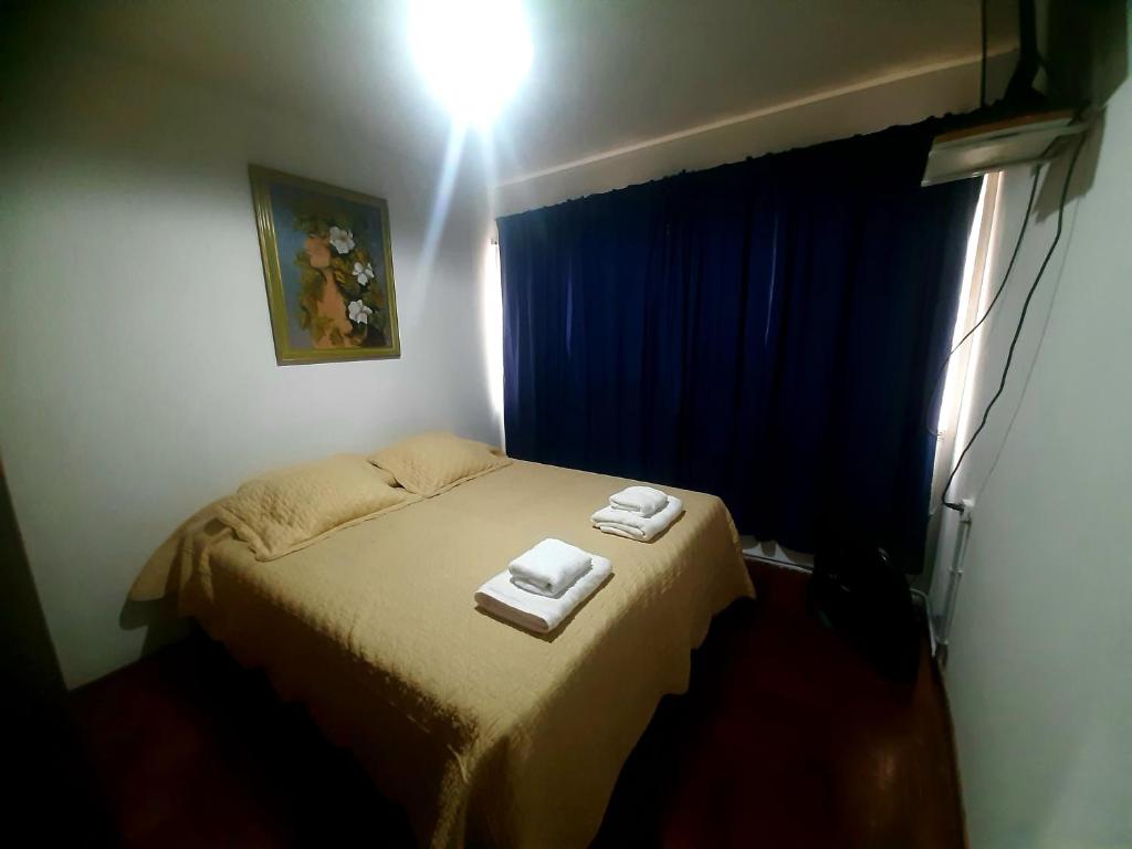 1 dormitorio con 1 cama con 2 toallas en Departamento Ciudad Mendoza en Mendoza