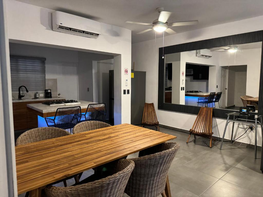 cocina y comedor con mesa de madera y sillas en Departamento en 1er piso 2 bdr 2bath tezal, en Cabo San Lucas