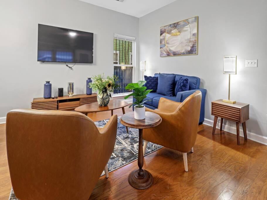 uma sala de estar com um sofá azul e cadeiras em La Petite Maison of Woodlawn em Memphis