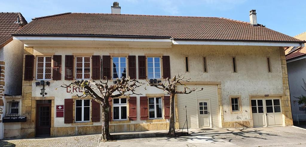 un edificio con dos árboles delante de él en Hotel Restaurant Croix Blanche, en Sugiez