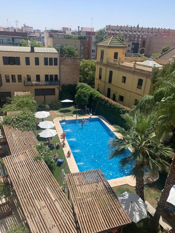 Hotel Apartamento próximo al centro de 2 dormitorios, an overhead view of a swimming pool with umbrellas and buildings at Apartamento próximo al centro de 2 dormitorios in Seville