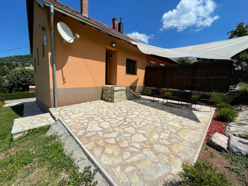 a house with a stone patio in front of it at Apartman Alibi in Boljevac