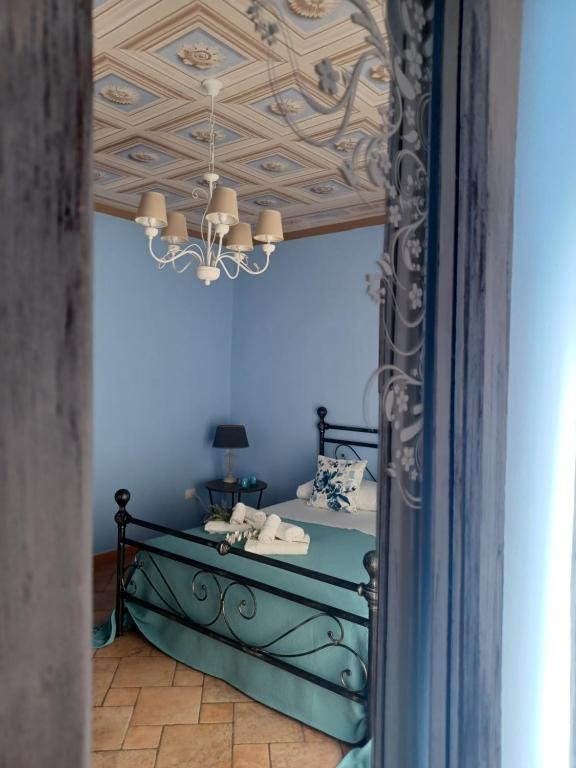 a blue room with a bed and a chandelier at Casa Vacanza Io e Te in San Marco Argentano