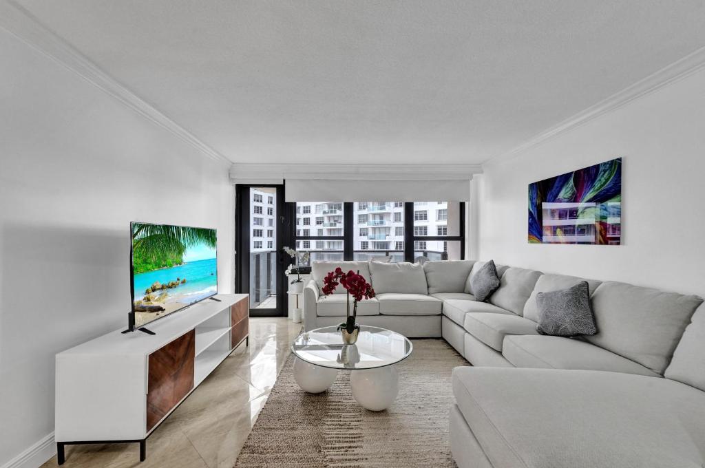 sala de estar blanca con sofá y TV en Cozy Ocean View Condo Beach Service 1015, en Miami Beach