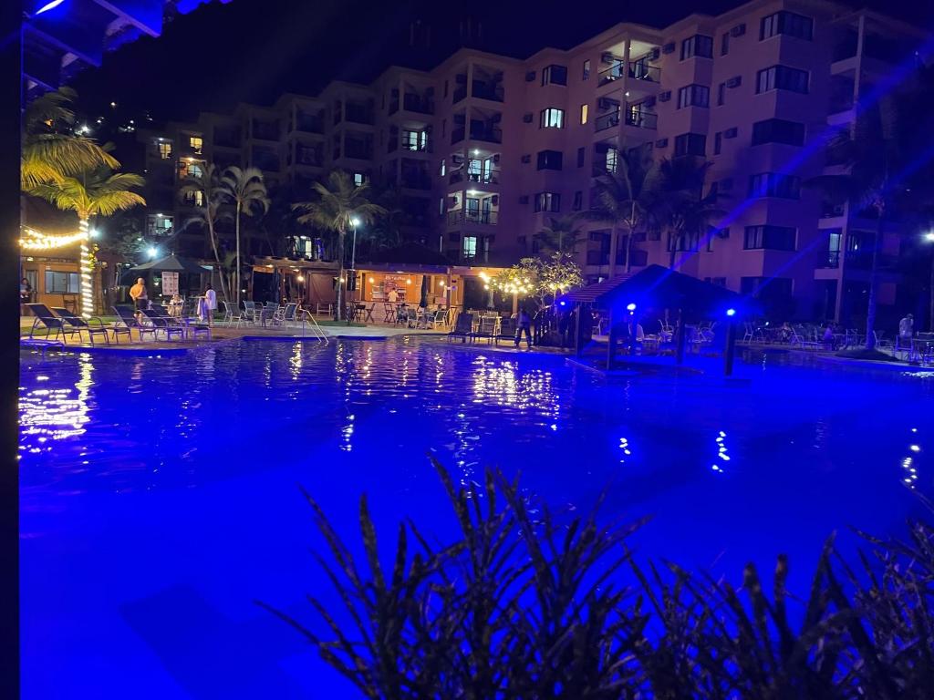 uma piscina à noite com luzes azuis em Não está disponível em Angra dos Reis
