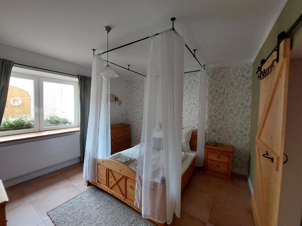 una camera con letto a baldacchino e finestra di NEU! Ferienwohnung Böhlitz Neun a Grimma