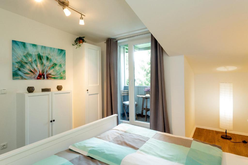 a white bedroom with a bed and a window at NEU! Appartement Zur Heideblüte in Toppenstedt