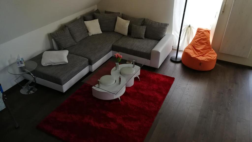 un soggiorno con divano e tappeto rosso di NEU! Galerie- Fewo mit Pool am Brombachsee a Theilenhofen