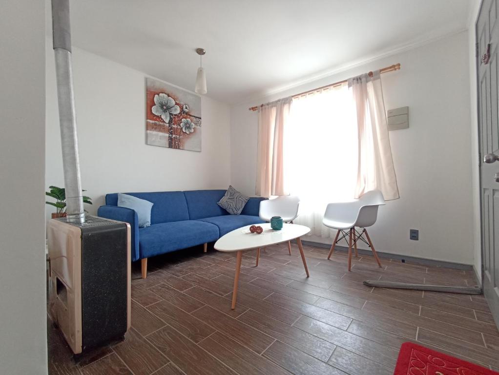 sala de estar con sofá azul y mesa en Casa PUQ en Punta Arenas