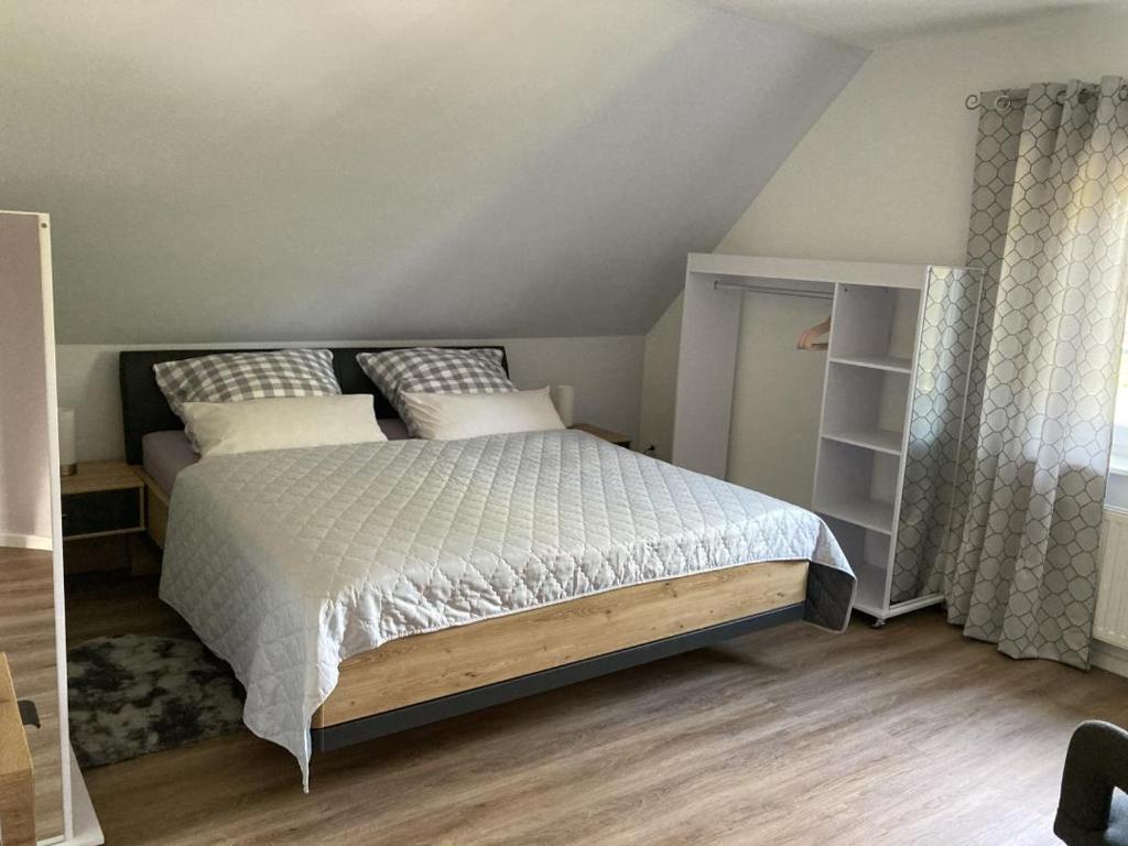 a bedroom with a bed with white sheets and pillows at NEU Ferienwohnung Hofmann in Husum