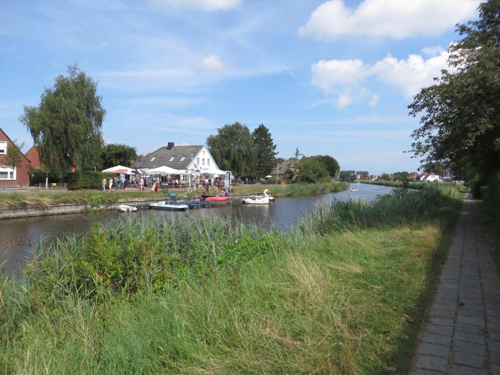 un fiume con barche e una casa di !!!NEU!!! Ferienwohnung an der Harle OG a Carolinensiel
