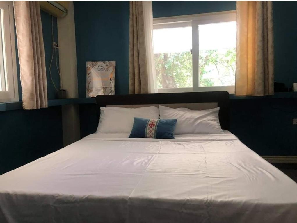 a large white bed with two pillows and a window at Omma's Beach House in Lian