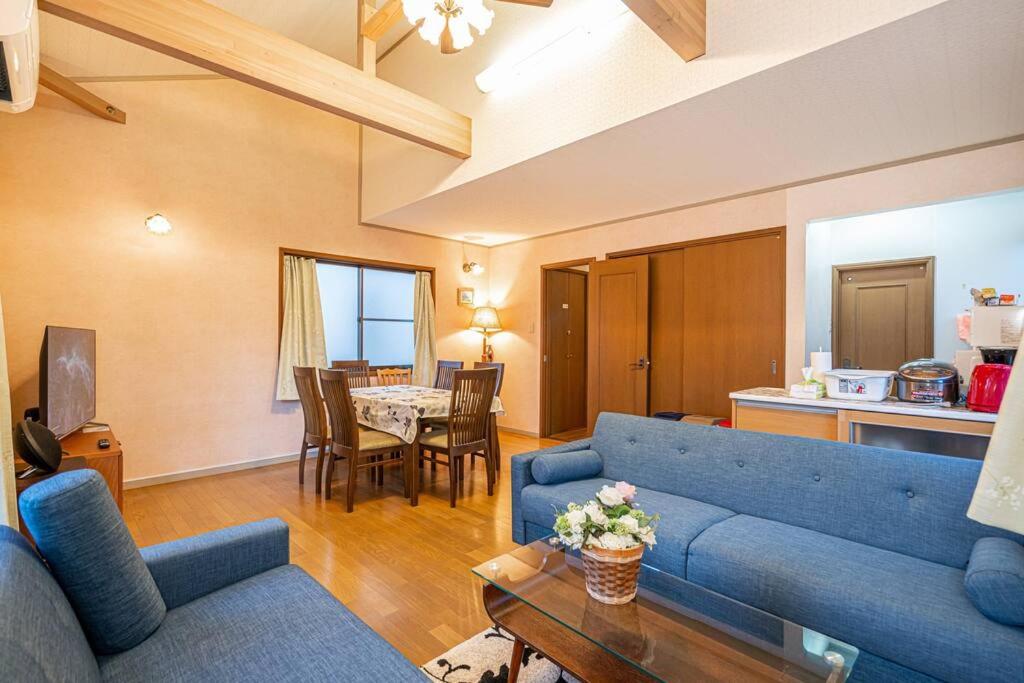 sala de estar con sofá azul y mesa en おもちゃ王国と北軽井沢の大自然を満喫できる貸別荘 en Karuizawa