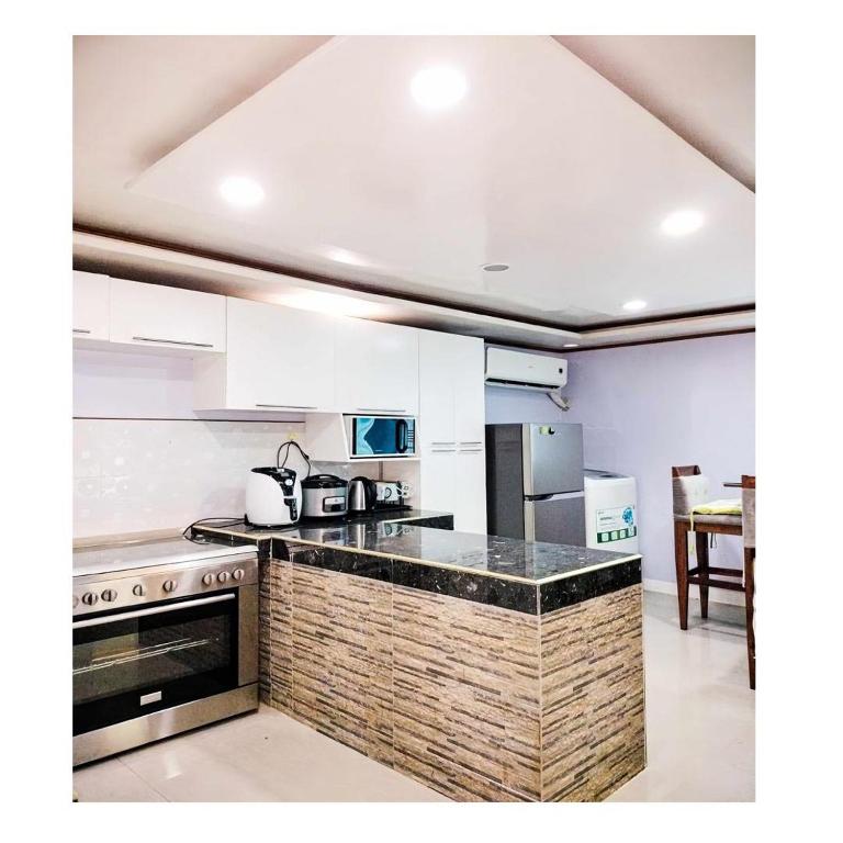 a kitchen with white cabinets and a counter top at Fely's transient house in Puerto Princesa City