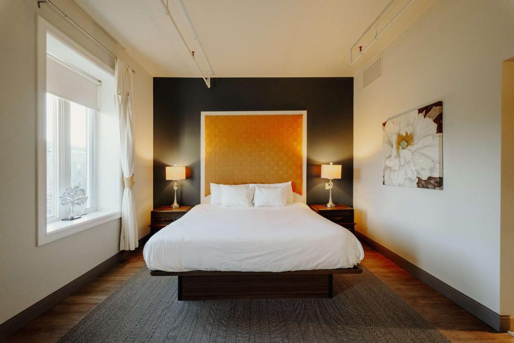 ein Schlafzimmer mit einem weißen Bett und zwei Lampen in der Unterkunft Mercer Hotel Downtown; BW Premier Collection in Stratford