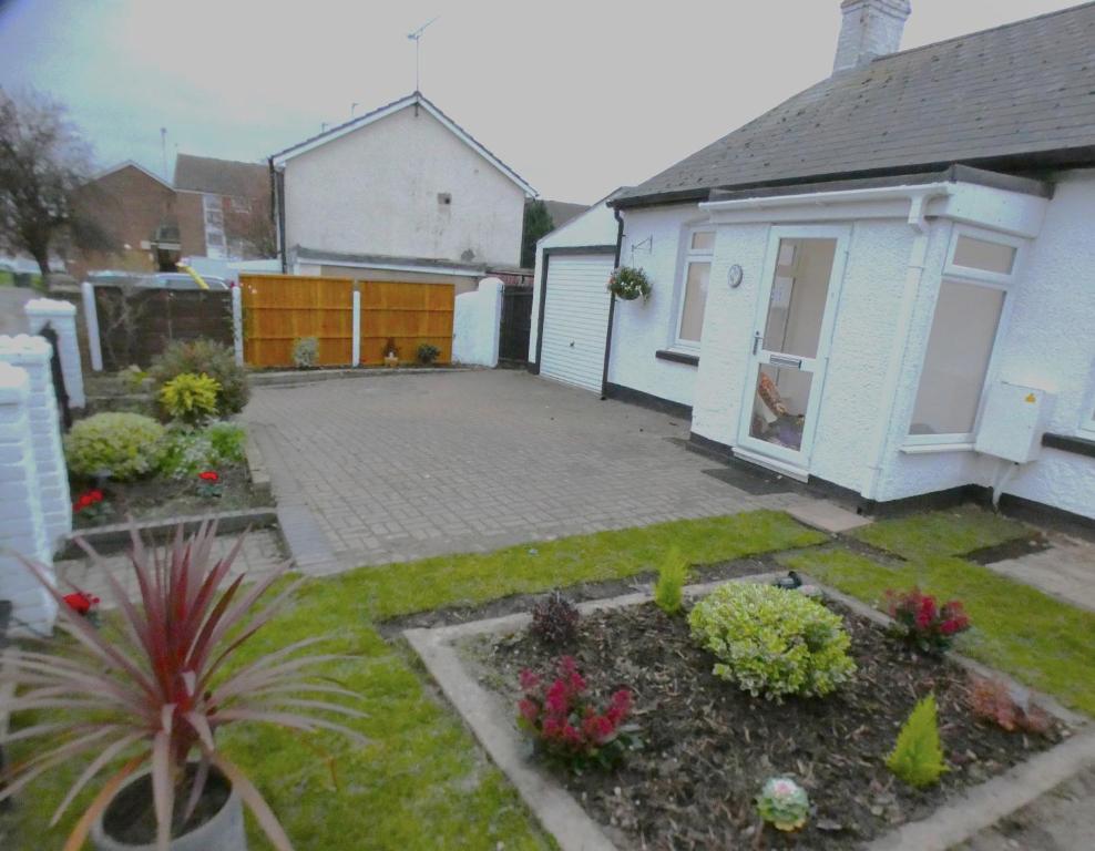 a backyard of a house with a courtyard with plants at 4 bedroom Bungalow in Slades Green