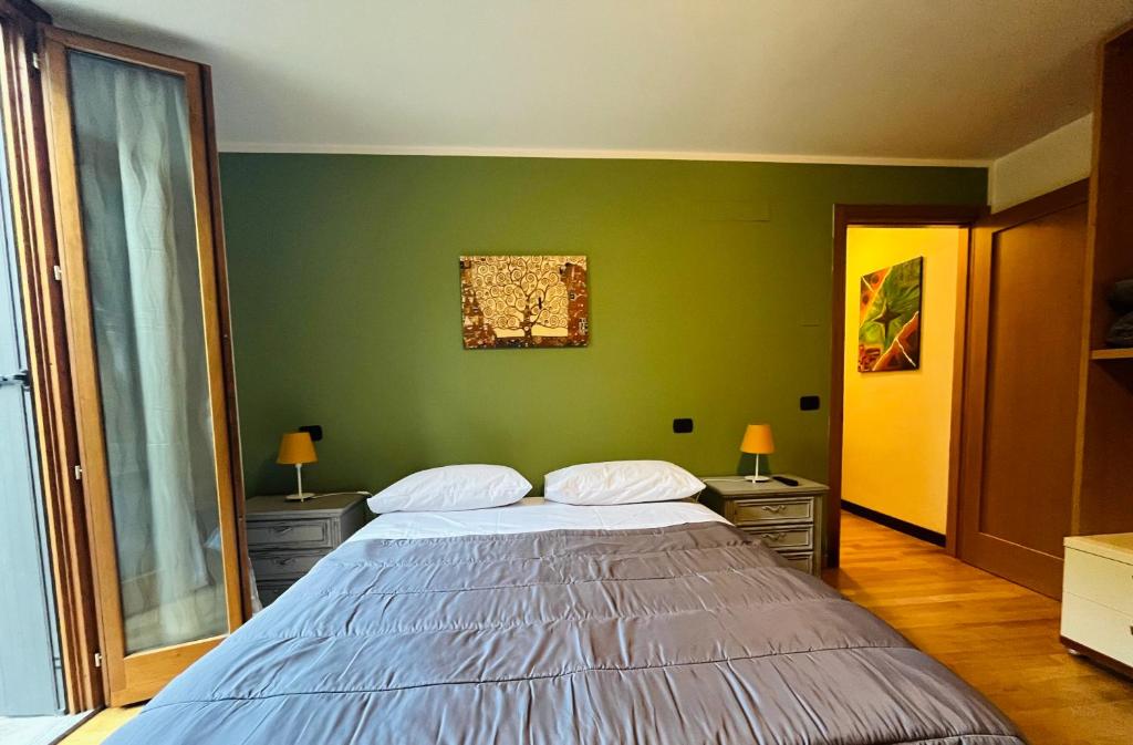 a bedroom with a large bed with green walls at B&B LE AMARENE in Sassuolo